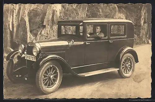 Foto-AK Auto Essex Super Six (1928), Mann in einem dunklen KFZ, geparkt an einer Felswand