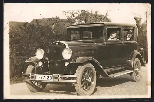 Foto-AK Auto Essex (1930), Zwei Männer schauen aus einem polierten schwarzen KFZ auf Kopfsteinpflaster