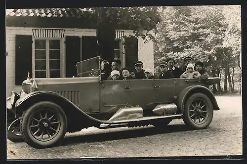 Foto-AK Auto Selve (1926), Familie mit sechs Kindern im geräumigen Fahrzeug in einer Ortschaft