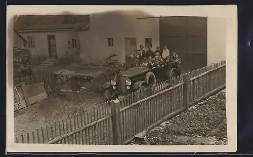 Foto-AK Auto Dux (1925), Grossfamilie mit ihrem geräumigen KFZ auf dem Hinterhof