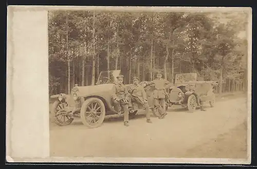 Foto-AK Auto Protos (1913), Uniformierte Soldaten an zwei Fahrzeugen im Wald