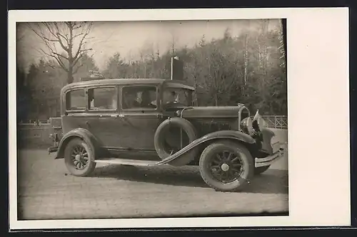 Foto-AK Auto Chrysler (1929), Ehepaar im KFZ auf einer gepflasterten Strasse