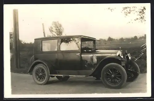 Foto-AK Auto Essex Six (1924 /25), Fahrzeug mir rückseitigen Ersatzreifen auf einer Landstrasse