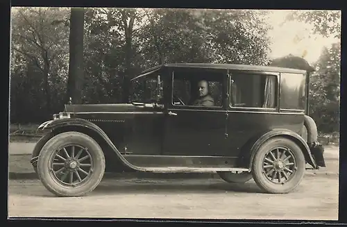 Foto-AK Auto Essex Six (1924 /25), Mann mit Glatze am Steuer eines schwarzen KFZ vor einem Park