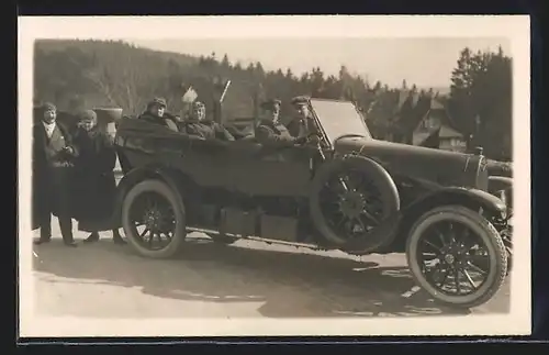 Foto-AK Auto Protos (1914), Dick gekleidete Ausflügler mit schwarzem Cabrio im Winter