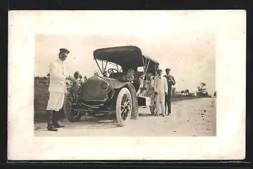 Foto-AK Auto Scat (1908), Chauffeur putzt die eine Lampe des Autos, Ausflügler warten