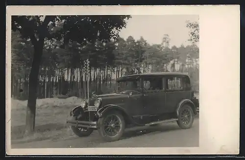Foto-AK Auto Essex (1928), Mann fährt in seinem Fahrzeug an einem Nutzforst entlang
