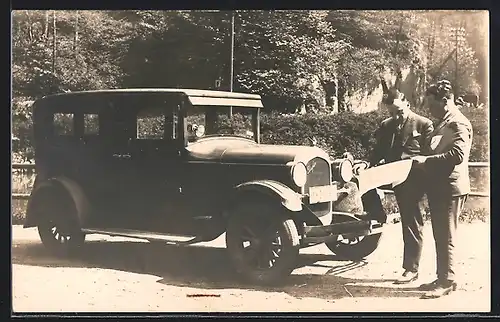 Foto-AK Auto Chrysler, Zwei Männer mit einer Landkarte vor ihrem KFZ