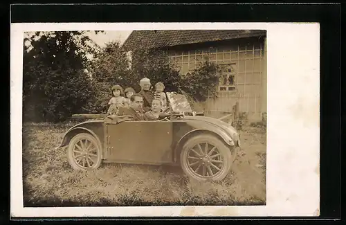 Foto-AK Auto Hannomag `Komissbrot`, Ehepaar im Fahrzeug, weitere Familie dahinter