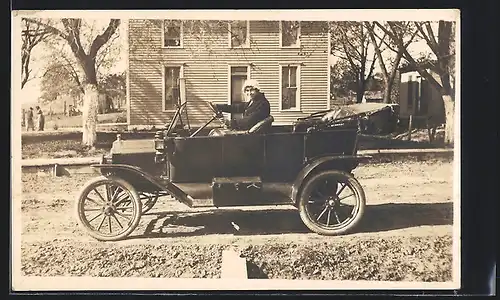 Foto-AK Auto Ford T, Frau am Steuer eines Fahrzeugs mit offenem Verdeck auf unbefestigter Strasse