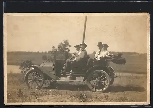 Foto-AK Auto Flanders (1909 /10), Vier Ausflügler im Fahrzeug auf einer Wiese am Fluss