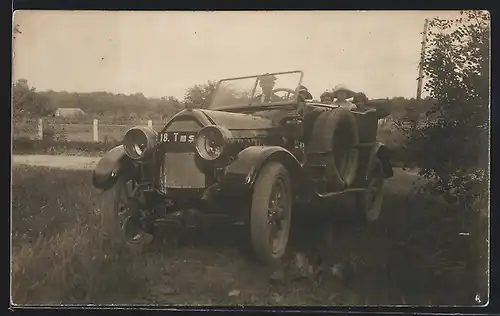Foto-AK Auto Peugeot 153 (1913), Ausflügler in einem schwarzen Cabrio an einer Landstrasse