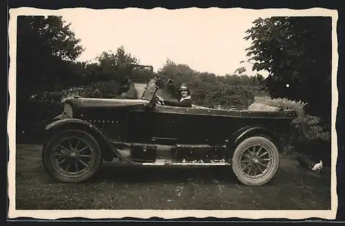 Foto-AK Auto Stoewer D5 (1921 /23), Junge Dame am Steuer eines Fahrzeugs auf einer Wiese neben Hühnern