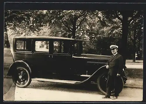 Foto-AK Auto Packard (1926), Chauffeur mit Mütze lehnt an seinem Wagen