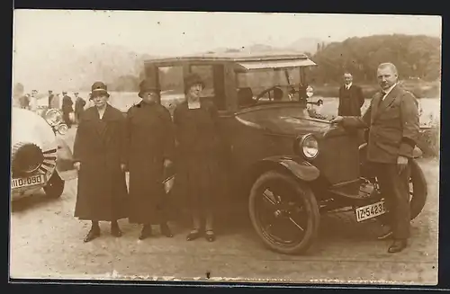 Foto-AK Auto Overland (1921), Stolzer Besitzer eines Automobils und drei Frauen