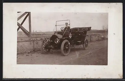 Foto-AK Auto Overland (1911), Fahrer im Wagen unterwegs