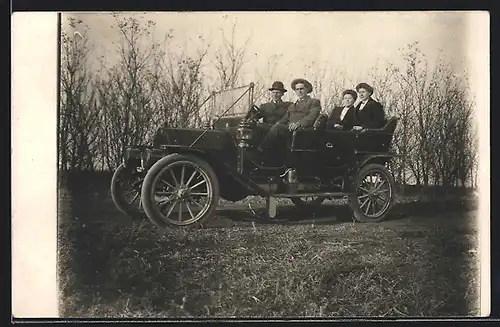 Foto-AK Auto Overland 42 (1910), Wagen auf einem Feld stehend mit zwei Paaren