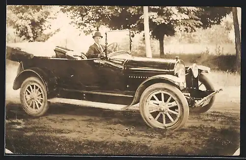Foto-AK Auto Oldsmobile (1918), Junger Herr mit Melone am Steuer seines Wagens