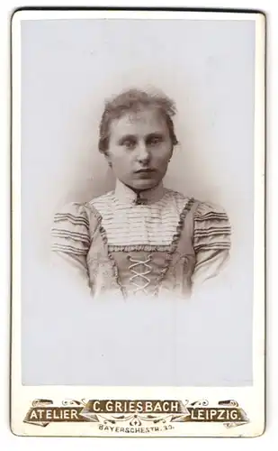 Fotografie C. Griesbach, Leipzig, Bayerschestr. 30, Junge Dame im hellen geschnürrten Kleid mit Brosche schaut gen Boden