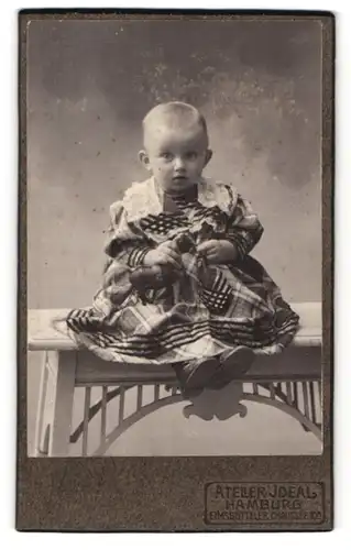 Fotografie Atelier Ideal, Hamburg, Elmsbütteler Chaussee 10, Niedliches Baby im karierten Kleid mit Spielzeugpferd