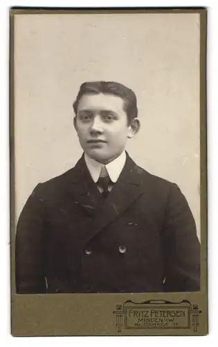 Fotografie Fritz Petersen, Minden, Kl. Domhof 11, Jüngling im schwarzen breiten Anzug mit Krawatte und Mittelscheitel