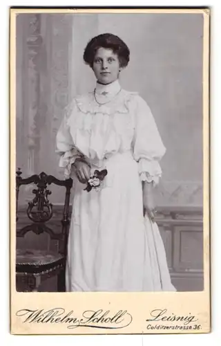 Fotografie Wilhelm Scholl, Leisnig, Colditzerstr. 36, Junge schöne Frau im weissen Sonntagskleid mit Halskette und Rosen