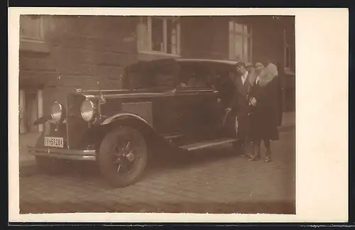 Foto-AK Auto Graham-Paige (1930), Zwei Frauen an einem eleganten schwarzen Fahrzeug mit einer Fahne am Kotflügel