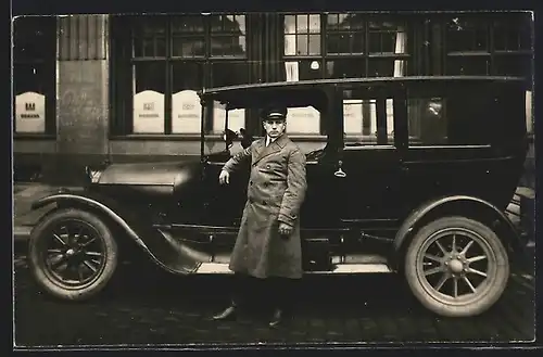 Foto-AK Auto Elite (192?), Fahrer an seinem Taxi vor einer Filiale der DEWEBA