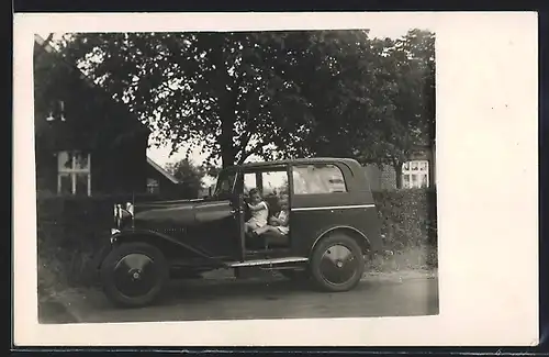 Foto-AK Auto Mathis, Zwei kleine Mädchen am Steuer eines KFZ mit offener Fahrertür