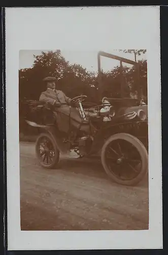 Foto-AK Auto Maurer-Union, Mann mit Mantel und Mütze am Steuer seines offenen Fahrzeugs
