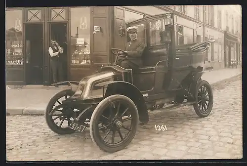 Foto-AK Auto Renault (1905 /08), Fahrer steht mit seinem Wagen vor einem Geschäft