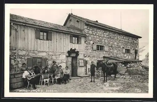 AK Simonyhütte, Leute sitzen vor der Berghütte