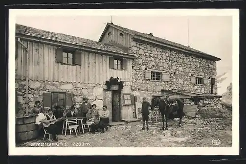 AK Simonyhütte, Leute sitzen vor der Berghütte