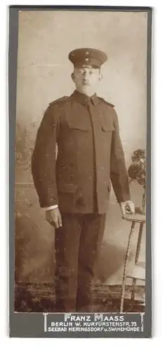 Fotografie Franz Maass, Berlin, Soldat in schmuckloser Uniform mit Schirmmütze