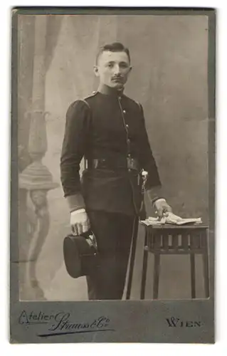 Fotografie Strauss & Co., Wien, K.u.K. Soldat in Uniform mit Säbel