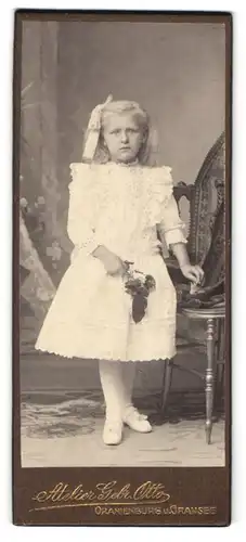 Fotografie Atelier Gebr. Otto, Oranienburg, Junges Mädchen im weissen, verzierten Kleid mit weisser Schleife im Haar