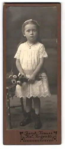 Fotografie Bernh. Krause, Kiel, Ringstr. 83, Junges Mädchen im weissen Kleid mit Rüschenelementen und Blumen in der Hand