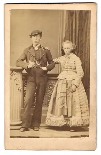 Fotografie unbekannter Fotograf und Ort, junges Paar im traditionellen Anzug und im karierten Kleid