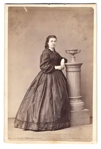 Fotografie unbekannter Fotograf und Ort, junge Dame im seidenen Kleid posiert an einer Säule