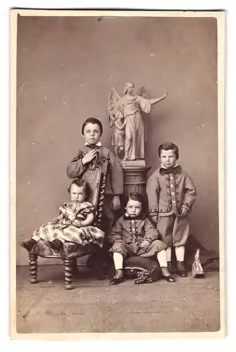 Fotografie unbekannter Fotograf und Ort, drei niedliche junge Knaben in Anzügen mit Schwester im Kleid, Engelstatue