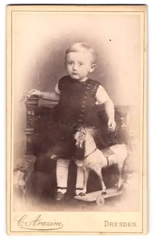 Fotografie C. Arazim, Dresden, kleines Kind mit seinem Spielzeug Pferd auf Rädern