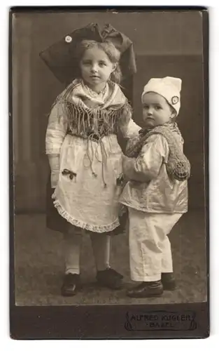 Fotografie Alfred Kugler, Basel, zwei niedliche kleine Kinder im Trachtenkleid und als Muschelsammler mit Netz