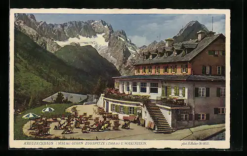 Künstler-AK Kreuzeckhaus, Die Terrasse der Berghütte gegen Zugspitze und Waxenstein