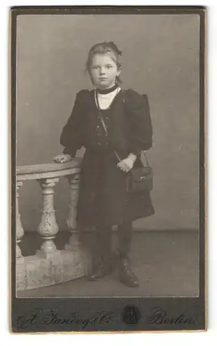 Fotografie A. Jandorf & Co., Berlin, Bellealliancestr. 1 /2, Junges Mädchen im schwarzen Kleid mit einer Handtasche