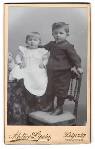 Fotografie Atelier Lipsia, Leipzig, Thomasring 15, Junge auf einem Stuhl mit kleiner Schwester