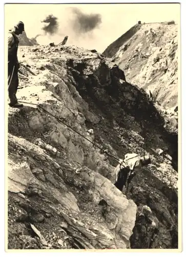 Fotografie unbekannter Fotograf, Ansicht Eisenerz, Bergmann / Kumpel mit Stemmeisen am Erzberg, Bergbau, Sicherungsseil