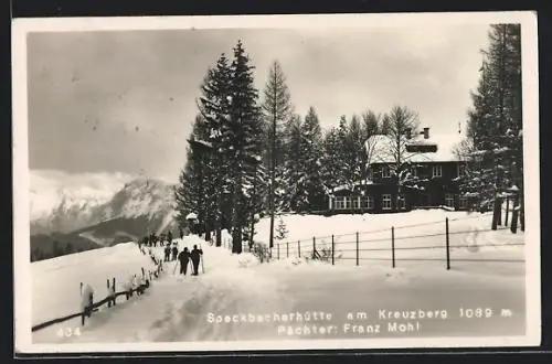 AK Speckbacherhütte, Pächter Franz Mohl, Skiläufer passieren die eingeschneite Berghütte am Kreuzberg