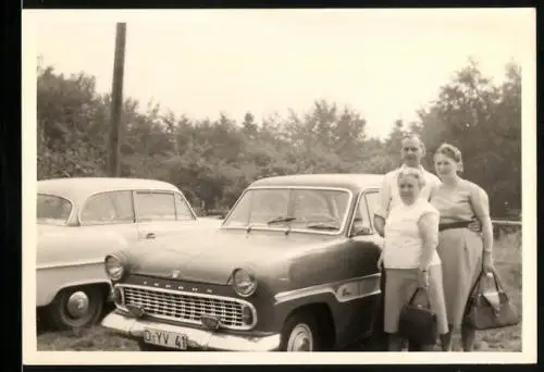 Fotografie Auto Ford Taunus, Herr & Damen auf einem Parkplatz