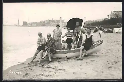 Foto-AK Rudergruppe in Badekleidung mit Boot am Strand