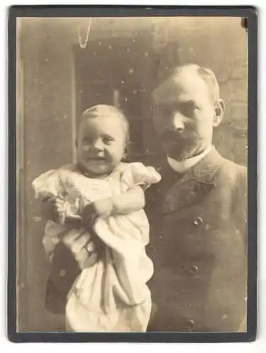 Fotografie unbekannter Fotograf und Ort, Bürgerlicher Herr mit Kleinkind auf dem Arm